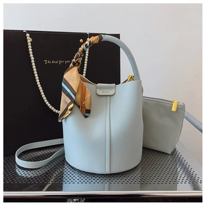 Close-up of light blue lychee pattern bucket bag with silk scarf and matching inner pouch