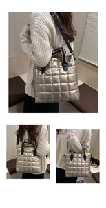 Detail of champagne gold quilted tote bag with black handles and metal texture finish