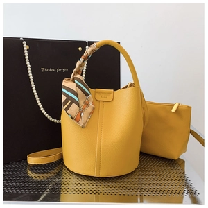 Detail of yellow lychee texture bucket bag with silk scarf handle and small pouch