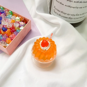 Handyhalterung als orangefarbener Pudding mit roter Kirsche und weißem Sahnehäubchen