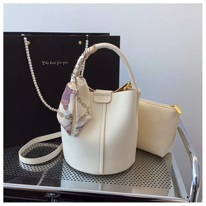 Detailed view of white lychee leather bucket bag set with decorative scarf and logo