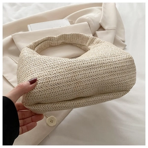 Detail of beige woven handbag showing intricate herringbone texture and minimalist moon shape