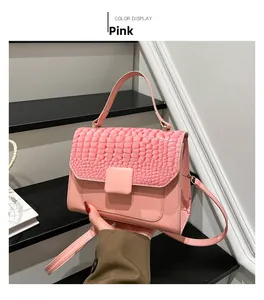 Detailed view of pink crossbody bag with crocodile pattern flap and square buckle
