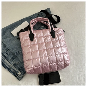 Detailed top view of pink quilted tote bag with black handles and a wide shoulder strap