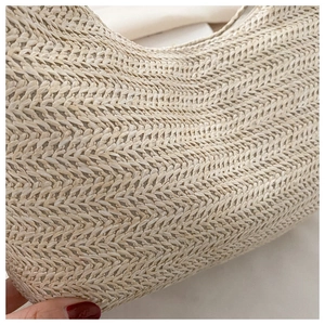 Macro shot of beige woven bag featuring high-quality herringbone weave and zipper closure