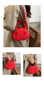 Detail of red suede shell-shaped mini bag with metallic studs and dual handles