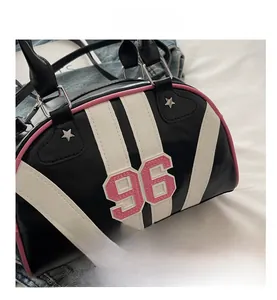 Detail of Boston bag showing pink number 96 embroidery and star rivets on black leather