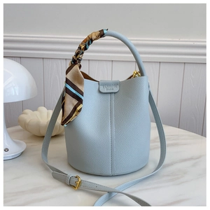 Close-up of light blue lychee pattern bucket bag with decorative silk scarf and strap