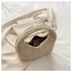 Detail of beige woven handbag with herringbone pattern and metal zipper closure
