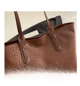 Dettaglio della trama intrecciata marrone scuro e cuciture rinforzate di una borsa tote
