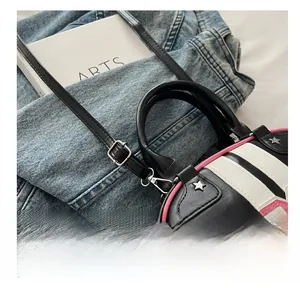 Close-up of tricolor leather handbag with metal star studs and adjustable strap detail