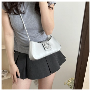 Detail of silver metallic mini bag featuring a sparkling crystal rectangular buckle