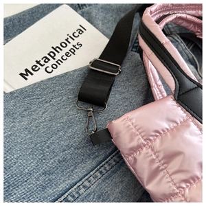 Detail of pink quilted puffer tote bag with black strap and gunmetal hardware hook