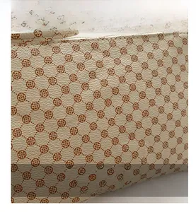 Detail of minimalist leather envelope bag featuring clover pattern and lychee texture