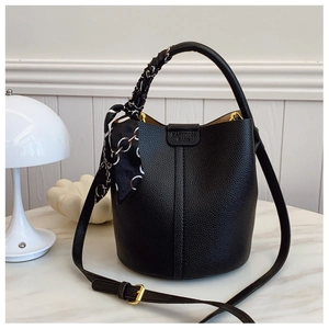 Detail of black lychee grain bucket bag with a decorative silk scarf on handle