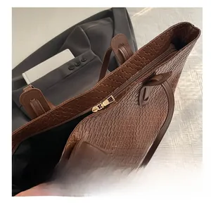 Dettaglio ravvicinato della cerniera dorata su una borsa tote marrone intrecciata