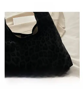 Close-up of black leopard print velvet tote bag texture showing soft matte fabric details