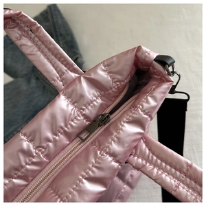 Close-up of pink quilted puffer tote bag with metallic sheen and sturdy zipper closure
