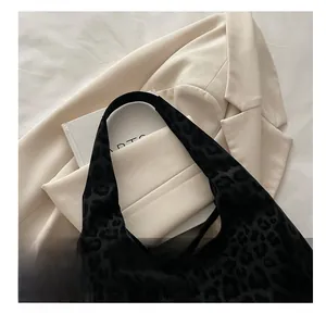 Top view of large leopard print tote bag with soft suede texture on beige blazer
