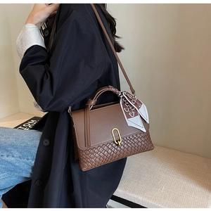 Brown leather crossbody bag featuring woven texture detail and silk scarf on handle