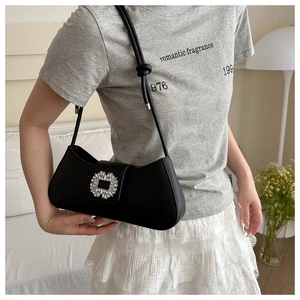 Close-up of black baguette bag with large crystal square buckle and knotted strap detail