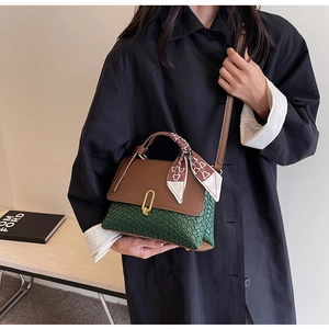 Detail of green woven leather handbag with brown flap and decorative silk scarf