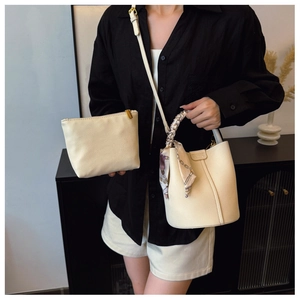 Detail of beige lychee leather bucket bag set with printed silk scarf handle decoration