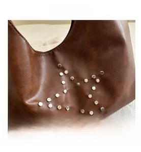 Close-up of brown faux leather texture with silver metal studs in star pattern