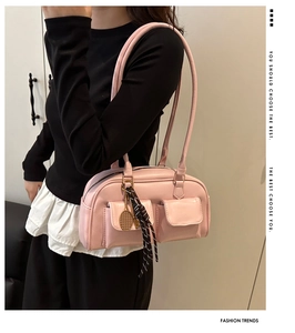 Detail of pink PU leather underarm bag featuring dual pockets and tennis racket charm