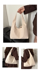 Detail of cream hobo bag showing soft PU leather texture and minimalist handle design