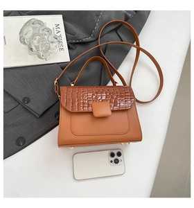Detailansicht der karamellbraunen Handtasche mit Krokoprägung und verstellbarem Gurt