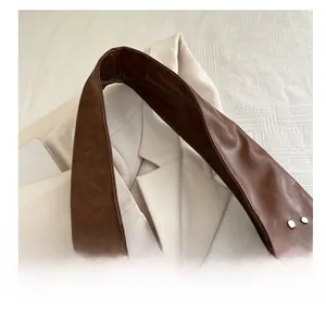 Close-up of brown litchi pattern leather shoulder strap with silver rivet details