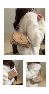 Detailed view of beige vintage underarm bag with metal buckles and side silver zippers
