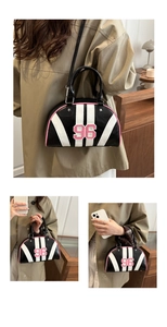 Close-up of retro bowling bag with pink 96 patch, star studs, and plaid lining detail