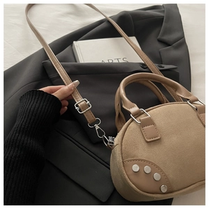 Detail of khaki vintage pillow bag with matte texture and silver metal studs on the base