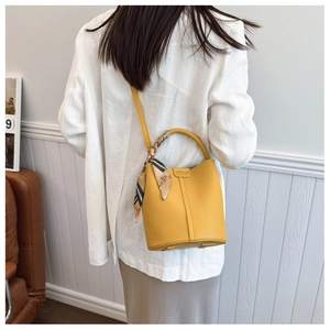 Litchi pattern yellow bucket bag with floral silk scarf on shoulder strap detail