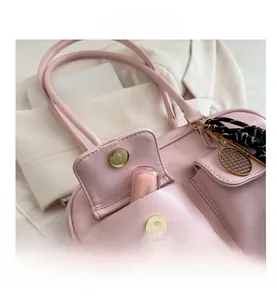 Pink shoulder bag detail showing two front magnetic pockets and golden tennis racket charm