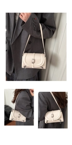 Detail view of cream shoulder bag with silver hardware buckles and dual zipper accents
