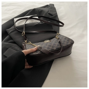 Dettaglio borsa a mezzaluna con motivo monogramma marrone e catena in metallo dorato