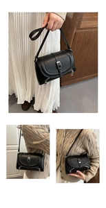 Detail view of black faux leather handbag with silver buckle and decorative side zippers