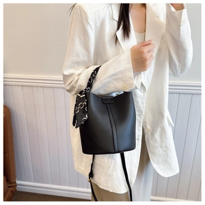 Litchi pattern bucket bag featuring a silk scarf detail and adjustable shoulder strap