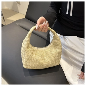 Detailed close-up of woven beige crescent tote bag with V-shaped texture and zipper closure
