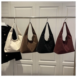 Detail showing four stylish tote bags in solid and leopard patterns on a metal rack
