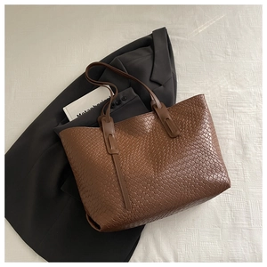 Dettaglio di una borsa tote intrecciata marrone in pelle pregiata e design capiente