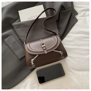 Detail view of a vintage dark brown leather shoulder bag with decorative silver buckle