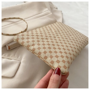 Close-up of minimalist beige envelope bag with brown floral pattern and pebble leather texture