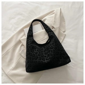 Detailed macro view of black leopard print texture on velvet shoulder tote bag for women