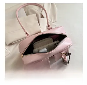 Top view of pink underarm bag interior showing storage space for phone and accessories