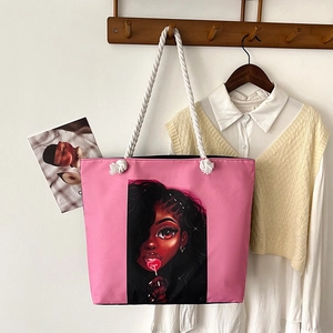 Detail of pink canvas tote bag featuring a colorful girl print and thick cotton rope handles