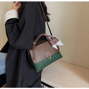 Detail of vintage patchwork handbag with green weaving, leather flap, and silk scarf handle